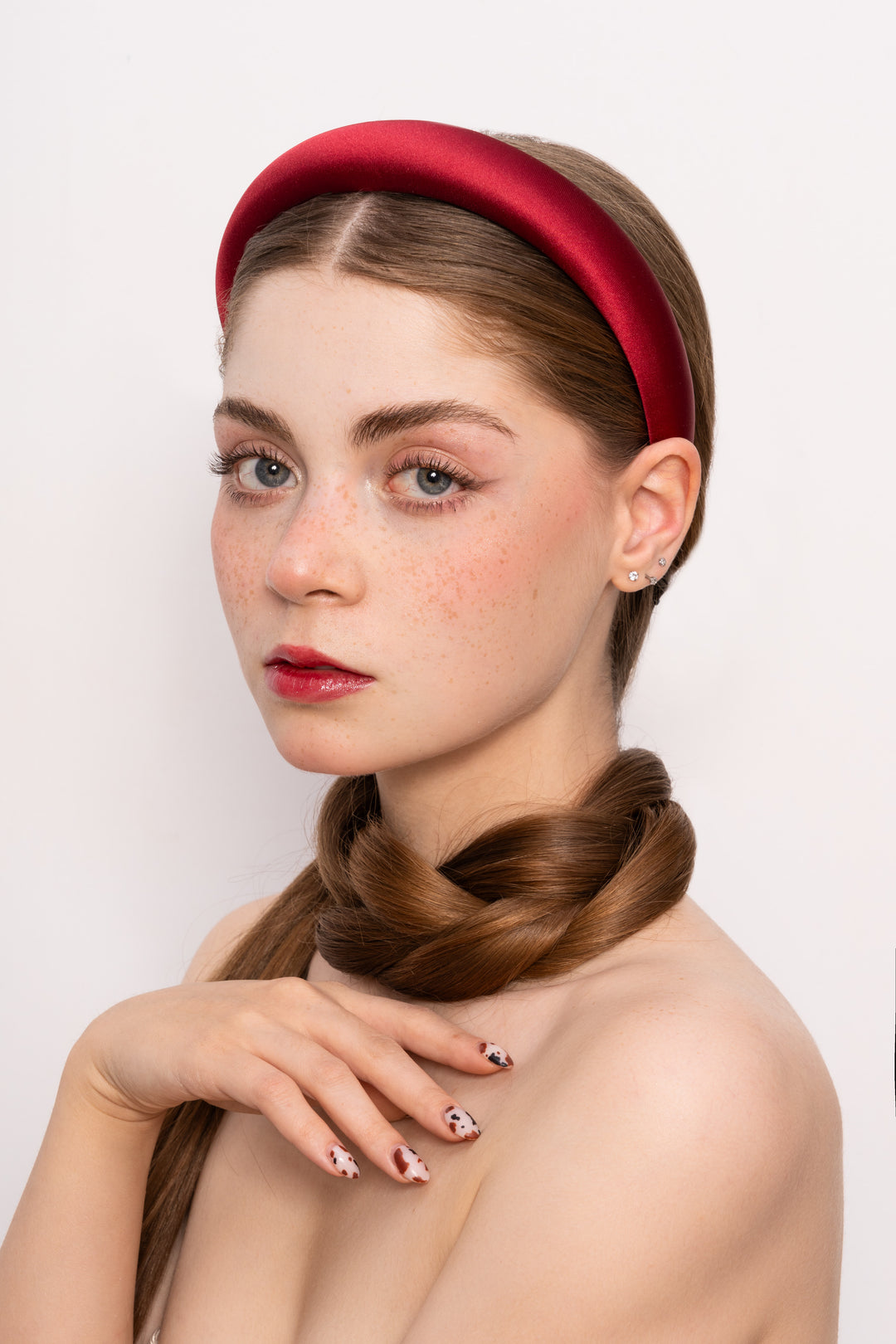 Woman wearing a red headband with a plain background